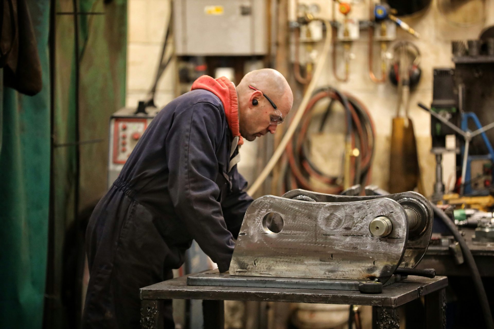 a man working on a metal object in a shop